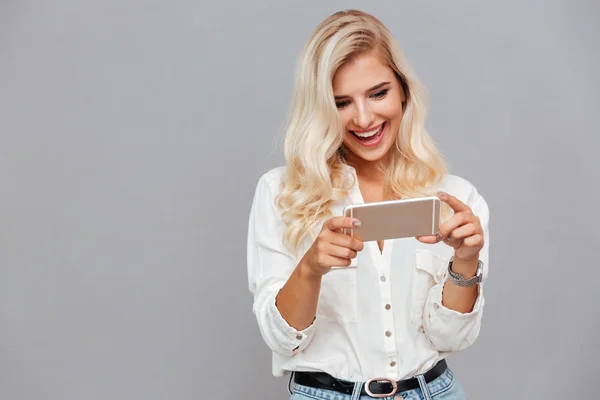 Vrolijke jonge vrouw met behulp van mobiele telefoon — Stockfoto