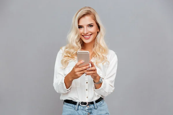 Mooie vrouw met mobiele telefoon smiling — Stockfoto