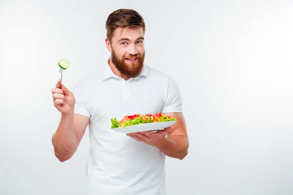 Jovem segurando garfo para comer farinha de salada vegetal fresca — Fotografia de Stock