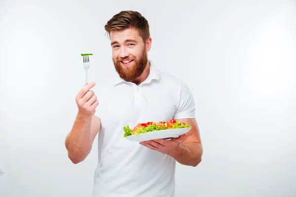 Retrato de um jovem bonito homem casual comendo salada — Fotografia de Stock