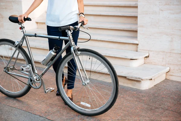 Przycięty obraz kobiet rowerzysta trzyma rower na ulicy — Zdjęcie stockowe