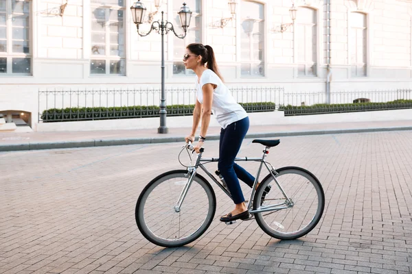 一个美丽的女人，骑在自行车上的侧面视图肖像 — 图库照片
