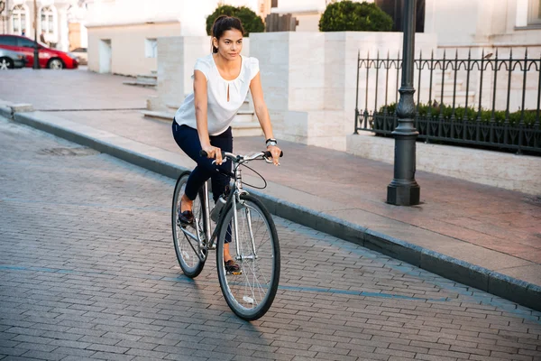 一个漂亮的女人，骑自行车在城市的肖像 — 图库照片
