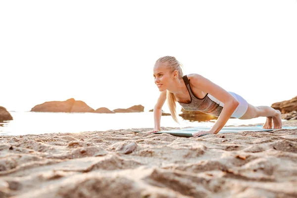 Portret kobiety blondynka robi szalunki na matę do jogi — Zdjęcie stockowe