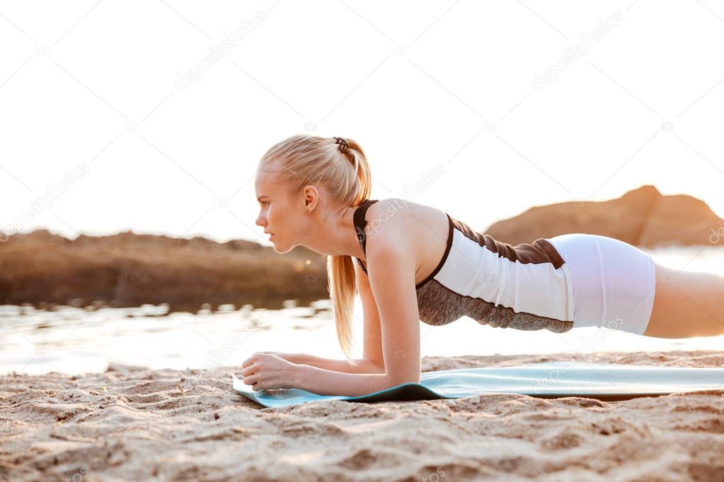 Close up portrait of a young woman doing plank exercises