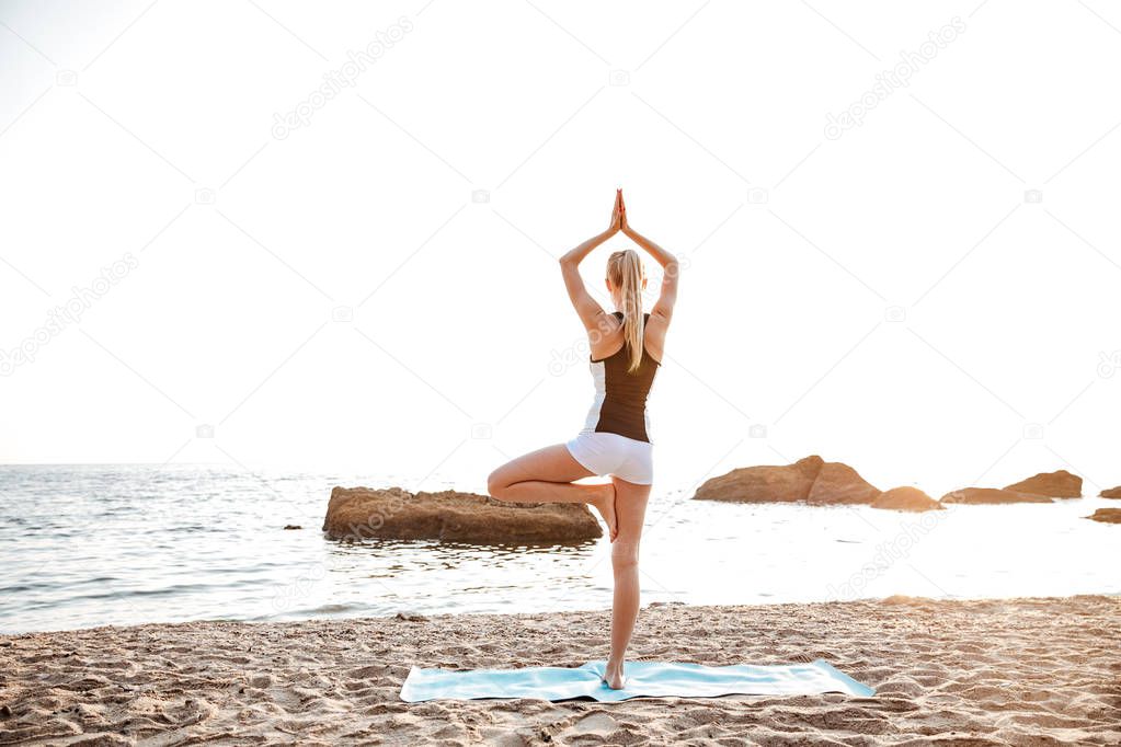 Back view of a woman standing in yoga pose