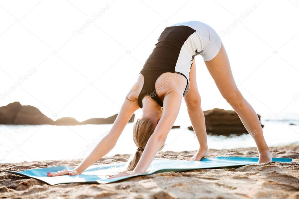 Portrait of a beautiful woman doing stretching exercises outdoors