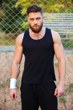 Kendine güvenen genç adam ayakta ve kameraya bakarak tshirt