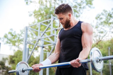 Egzersiz ve halter kaldırma ciddi genç adam atlet