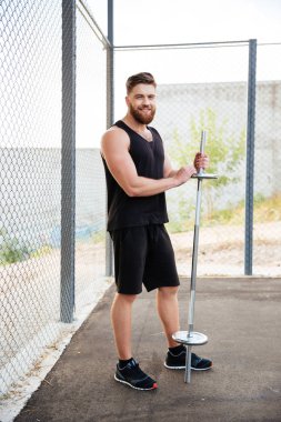 Halter tutan yakışıklı bir genç gülümseyen fitness adam portresi