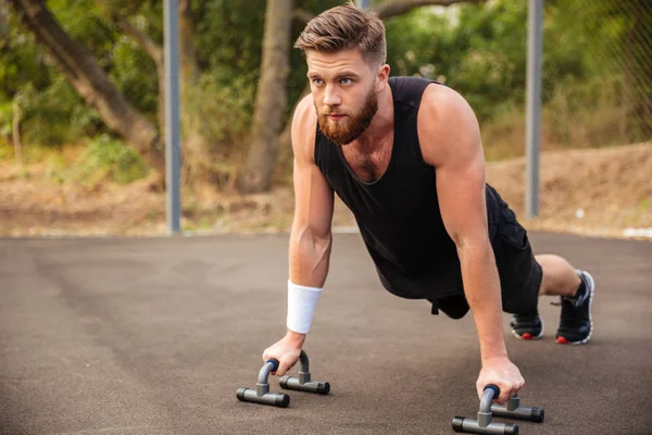 Şınav ve spor malzemeleri kullanarak kas fitness adam