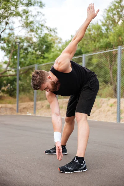 Porträtt av atletisk skäggig man göra stretchingövningar — Stockfoto