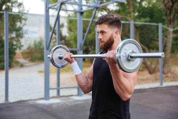 Мышцы красивый мужчина тренировки с штангой — стоковое фото