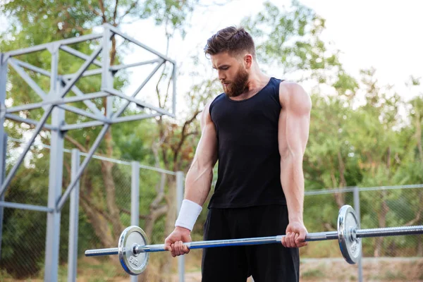 Kendine güvenen genç fitness adam barbell ile yapıyor