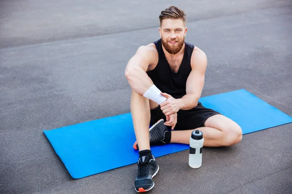 Joven atleta feliz hombre descansando y beber agua después del entrenamiento — Foto de Stock