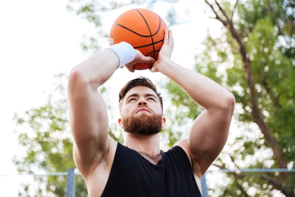 Retrato de un hombre guapo en ropa deportiva jugando baloncesto — Foto de Stock