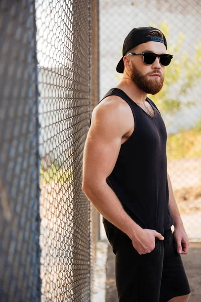 Yakışıklı adam metal kentsel çit yaslanmış portresi