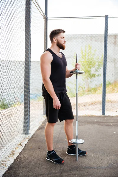 Ciddi bir sakallı sporcu halter tutarak tam uzunlukta portresi — Stok fotoğraf