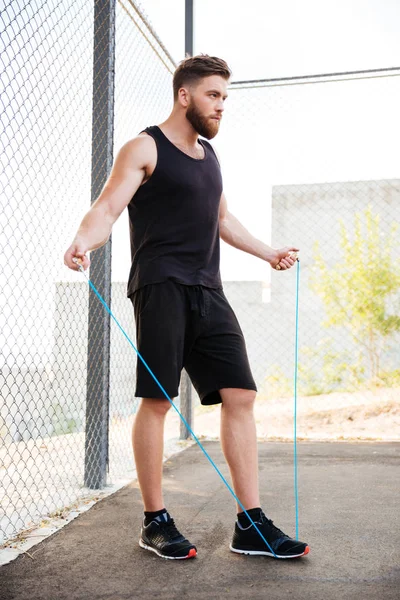 Konzentrierter Fitness-Mann macht Cardio-Übungen mit Springseil im Freien — Stockfoto