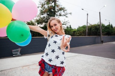 Mutlu genç kadın renkli lateks balonlar ile eğleniyor