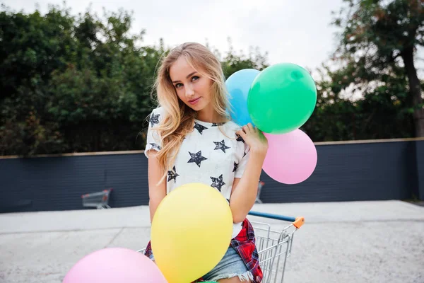 Güzel genç bir kadın elinde balonlarla — Stok fotoğraf