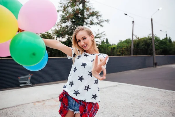 Mutlu genç kadın renkli lateks balonlar ile eğleniyor