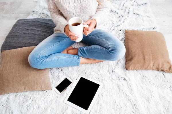 Kobieta z pustego ekranu tabletu i smartfona w pomieszczeniu — Zdjęcie stockowe