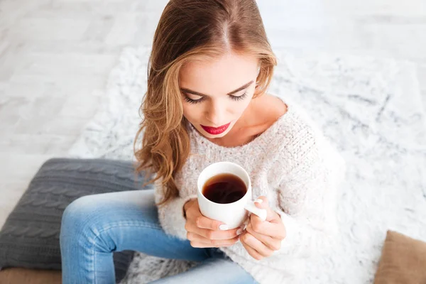 Mujer con el pelo largo y lápiz labial rojo sosteniendo taza de té —  Fotos de Stock