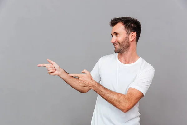 Retrato de un hombre casual feliz señalando con los dedos — Foto de Stock