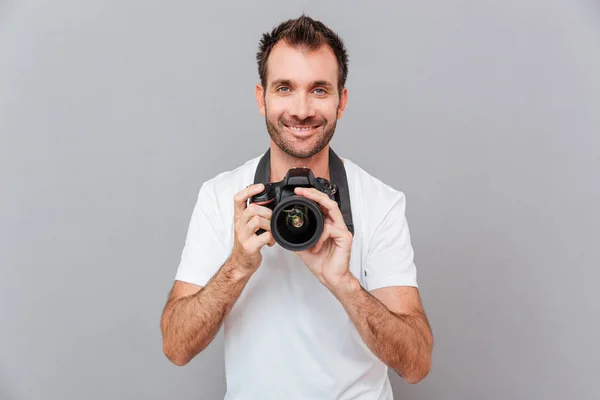 Portret van een lachende knappe man met camera — Stockfoto