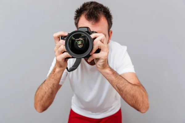 Porträtt av en manlig fotograf med kamera ta foto — Stockfoto