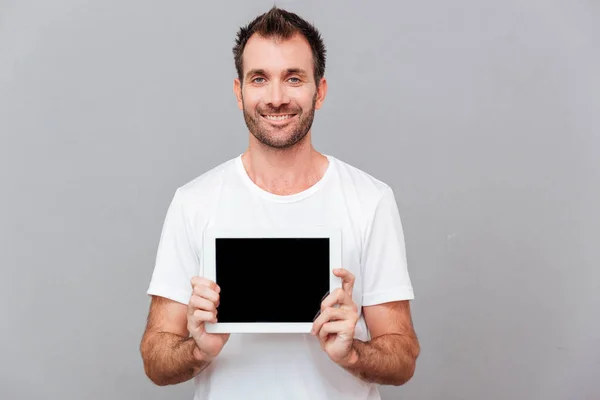 Casual adam boş tablet bilgisayar ekranında gösterilen gülümseyen — Stok fotoğraf