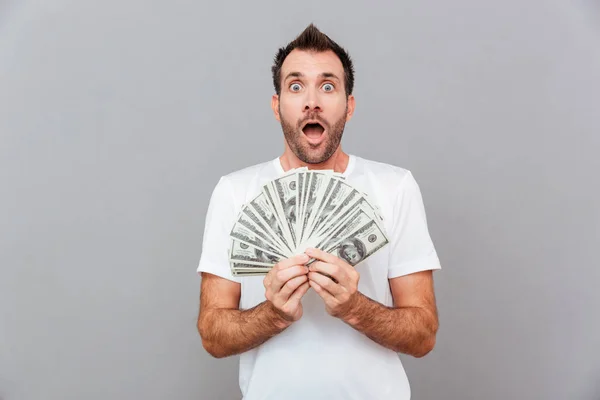 Hombre casual feliz sosteniendo billetes de dólares — Foto de Stock