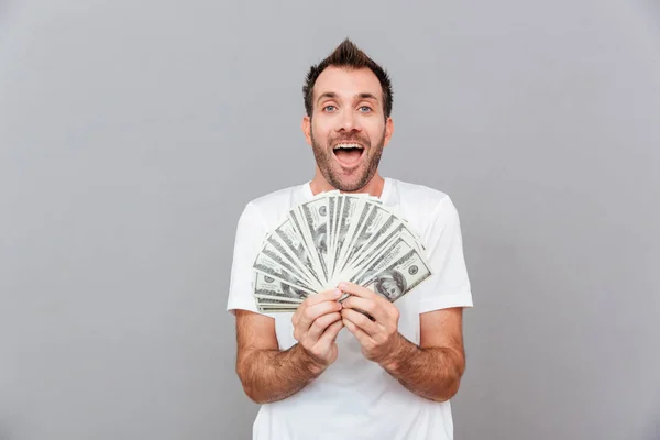 Retrato de un hombre alegre sosteniendo billetes de dólar —  Fotos de Stock