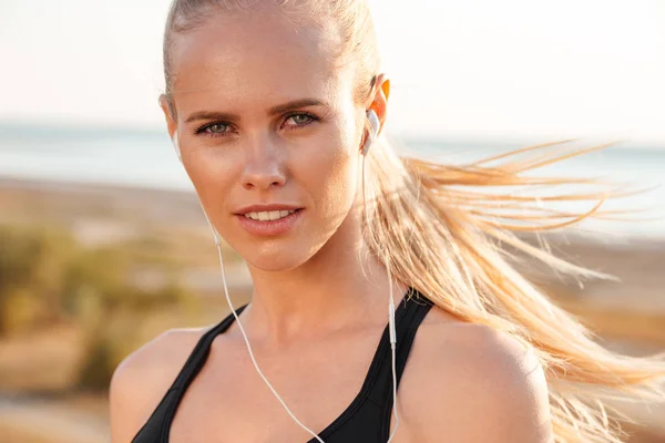 Retrato de una mujer deportiva con auriculares al aire libre — Foto de Stock