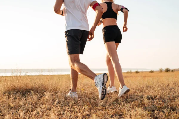 Young fitness man and woman doing jogging sport outdoors — Stock Photo, Image