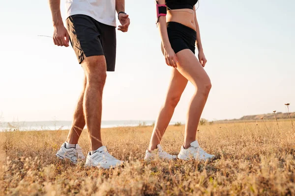 Imagen recortada de una joven pareja de fitness caminando en la colina — Foto de Stock