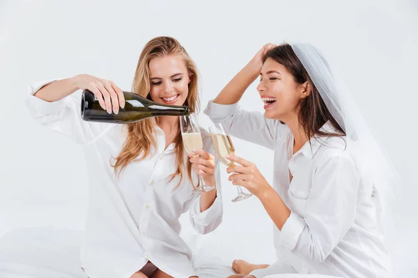 Due giovani donne che danno festa di fidanzamento con bottiglia di champagne — Foto Stock