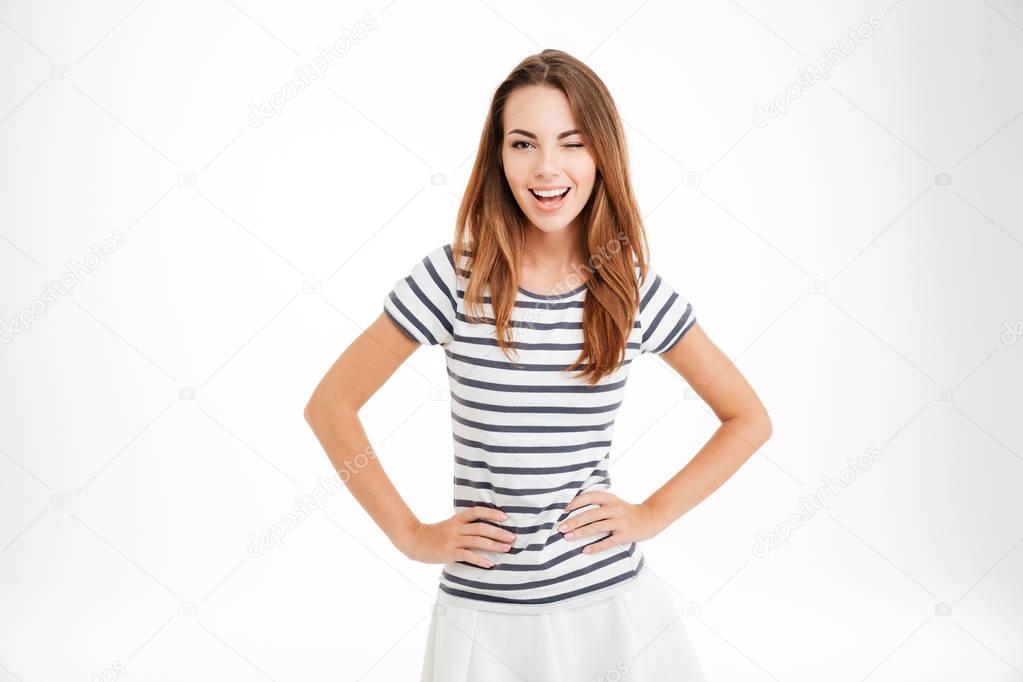 Happy attractive casual girl standing and winking