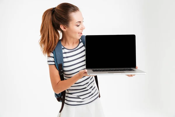 Glad ung kvinna visar tom laptop skärm — Stockfoto