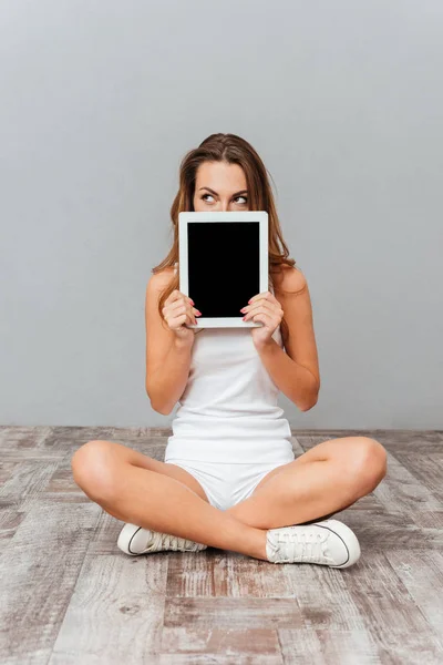 Retrato de uma mulher cobrindo seu rosto com computador tablet — Fotografia de Stock