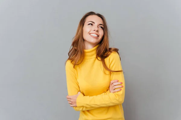 Wesoły młoda kobieta w żółty sweterek stojąc z rękami skrzyżowanymi — Zdjęcie stockowe