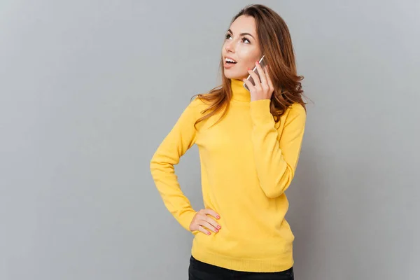 Femeie în pulover galben vorbind la telefon și uitându-se departe — Fotografie, imagine de stoc