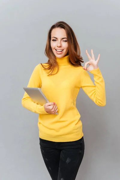 Mujer con el ordenador tableta guiño y mostrando signo ok —  Fotos de Stock