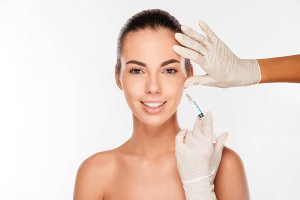 Young woman gets beauty injection in eye area from sergeant — Stock Photo, Image