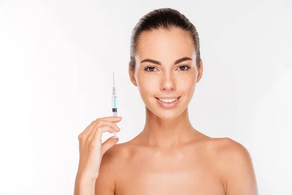 Young beautiful woman holding medical syringe in hand — Stock Photo, Image