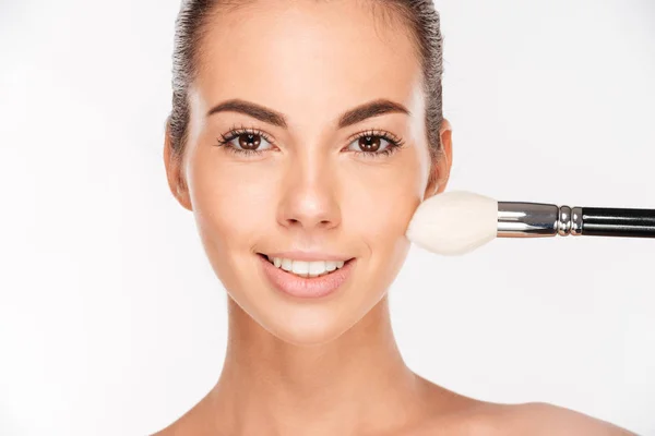 Beautiful young woman apply powder on her face — Stock Photo, Image