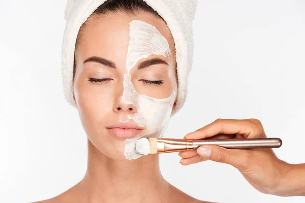 Woman getting beauty skin mask treatment on face with brush — Stock Photo, Image