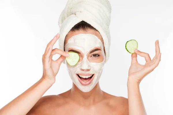 Woman with facial mask and cucumber slices in her hands — Stock Photo, Image
