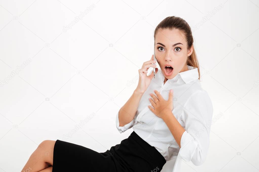 Surprised young businesswoman talking on the mobile phone